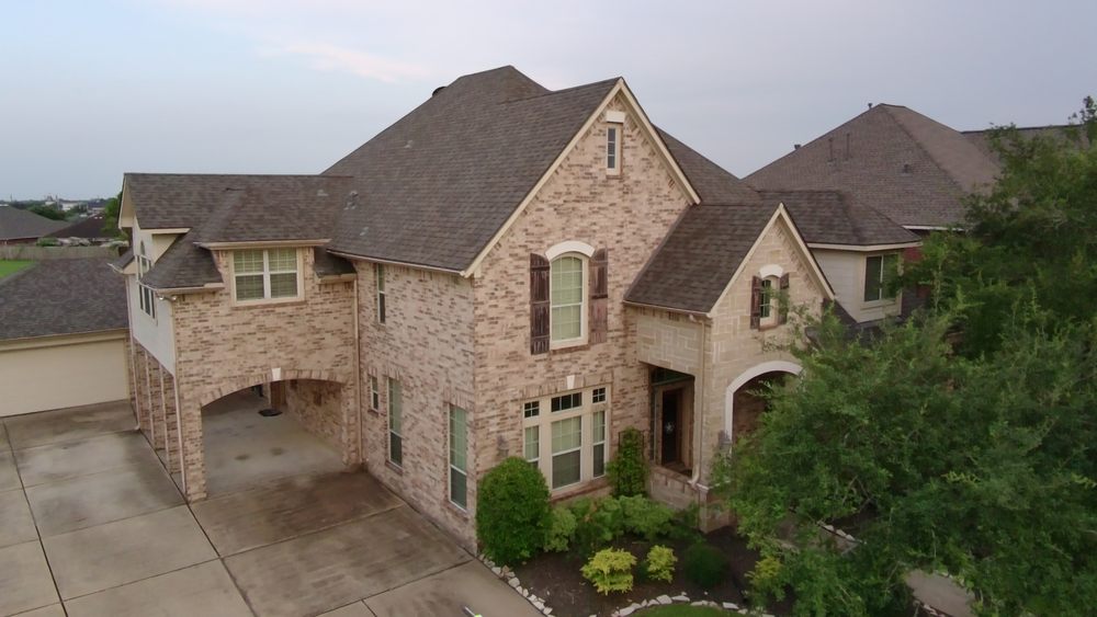 Completed roof replacement on a two-story Houston-area brick home