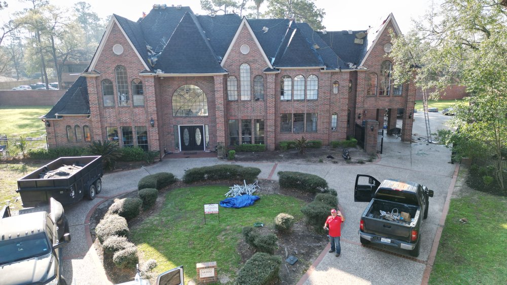 Full roof replacement in progress on a large Houston brick mansion